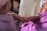 A caring volunteer gently holding hands with an elderly parent and their adult child.