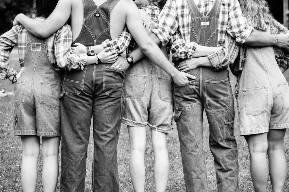 grayscale photography of group of people hugging each other