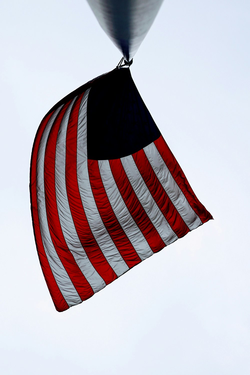 낮 동안 검은 금속 기둥에 미국 국기