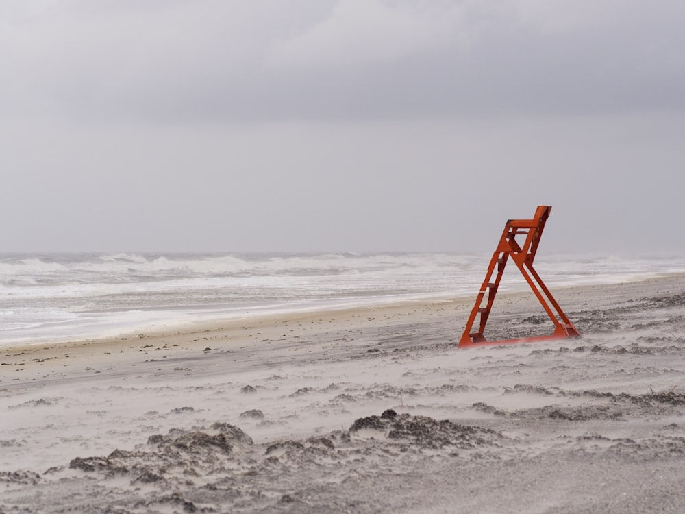 red metal ladder stand near seashore during daytime