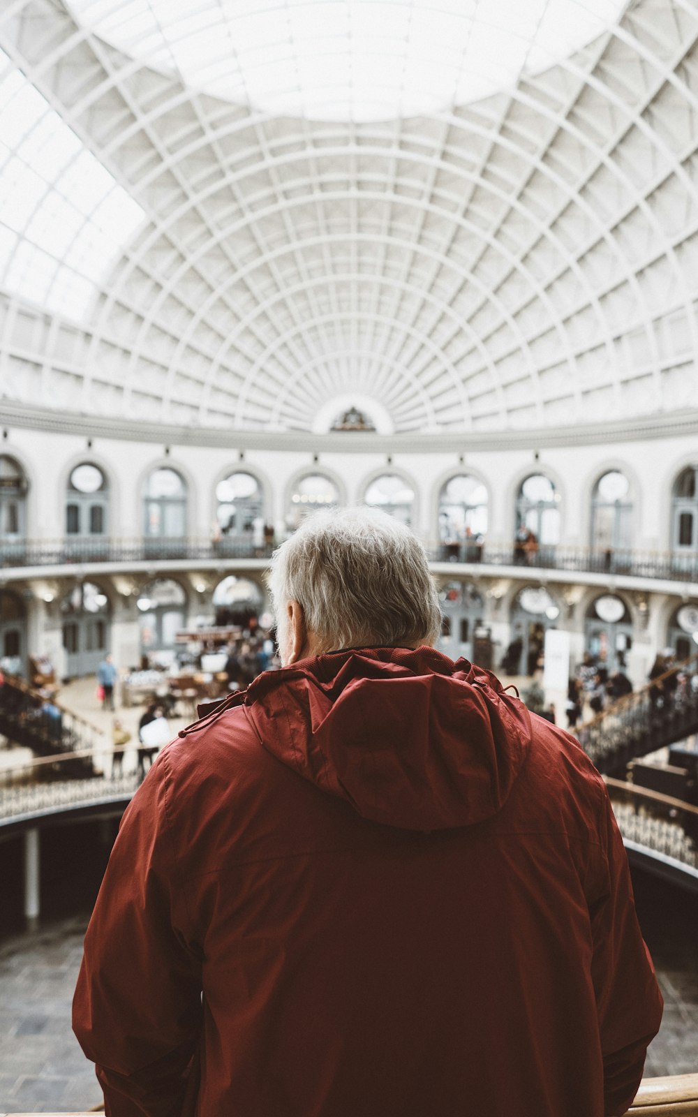 man wearing red hoodie inside dome building in front of people