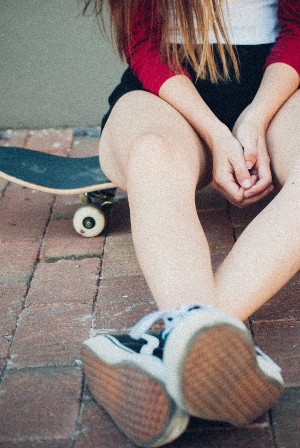 woman sitting on black skateboard during daytime