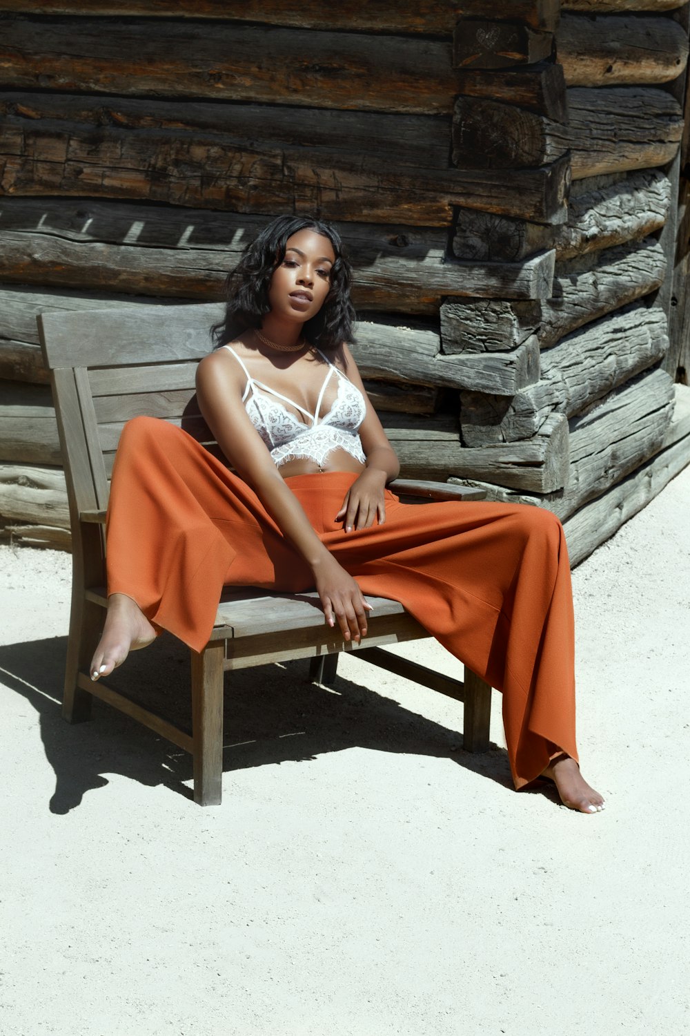 woman sitting on brown wooden armchair outdoor