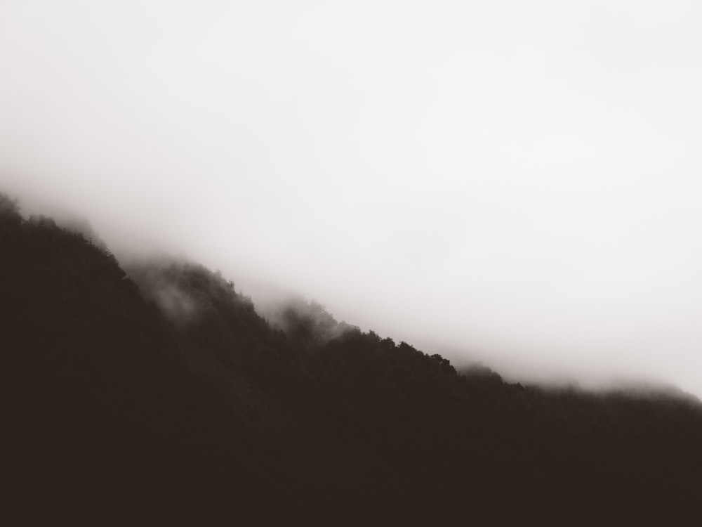 Una foto in bianco e nero di una montagna nebbiosa