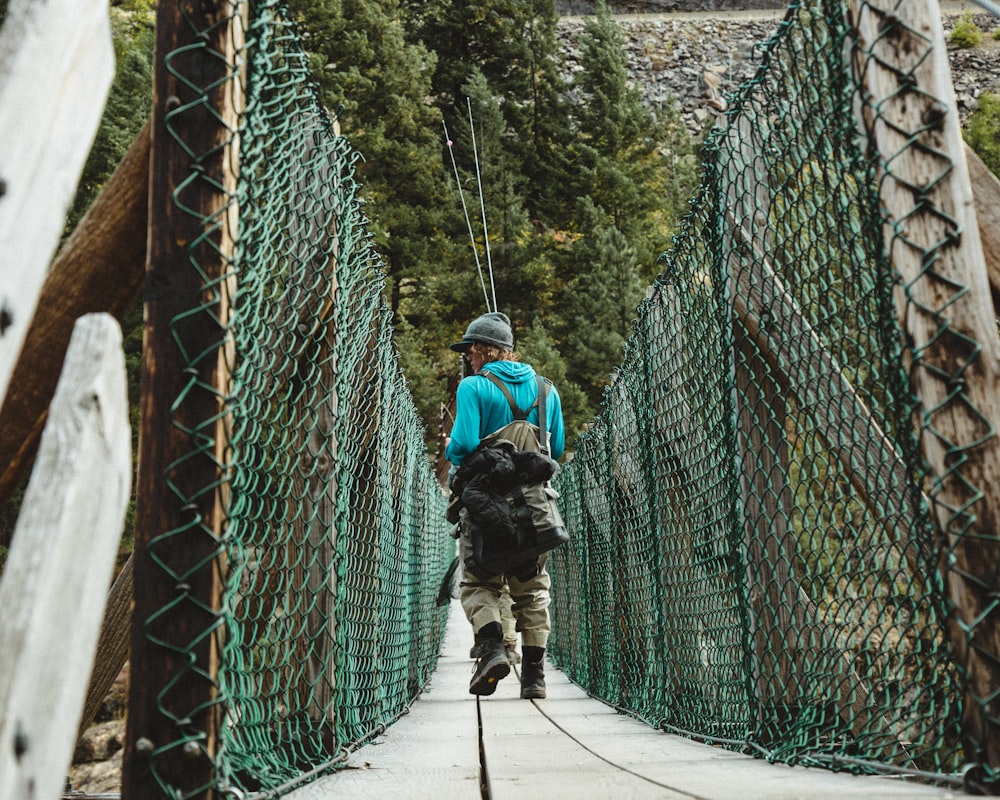 Mann auf grüner Hängebrücke