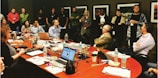 A diverse group of scientists discussing findings in a conference room.