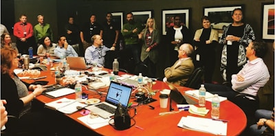 A group of diverse professionals in a meeting room discussing strategy.