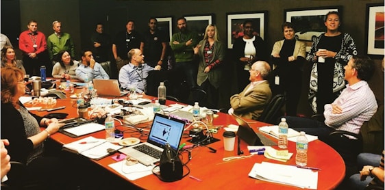 A diverse group of professionals collaborating around a conference table with event planning materials.