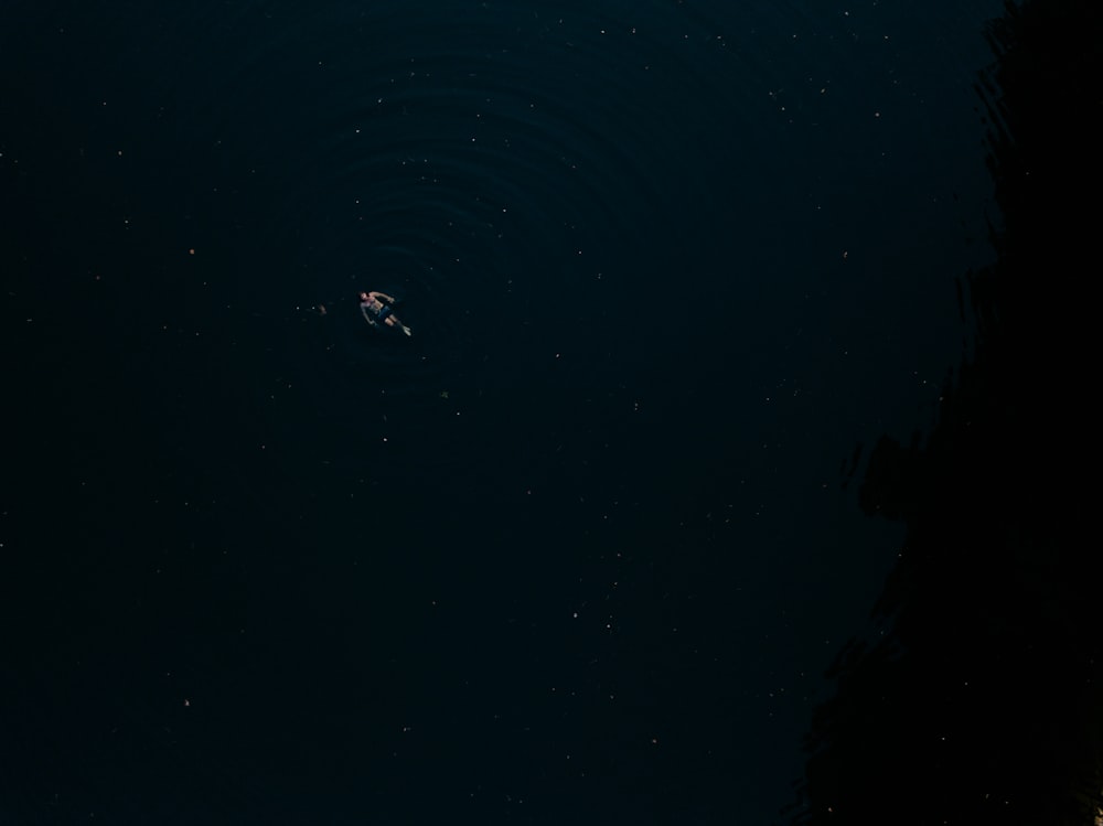a person floating in a body of water at night