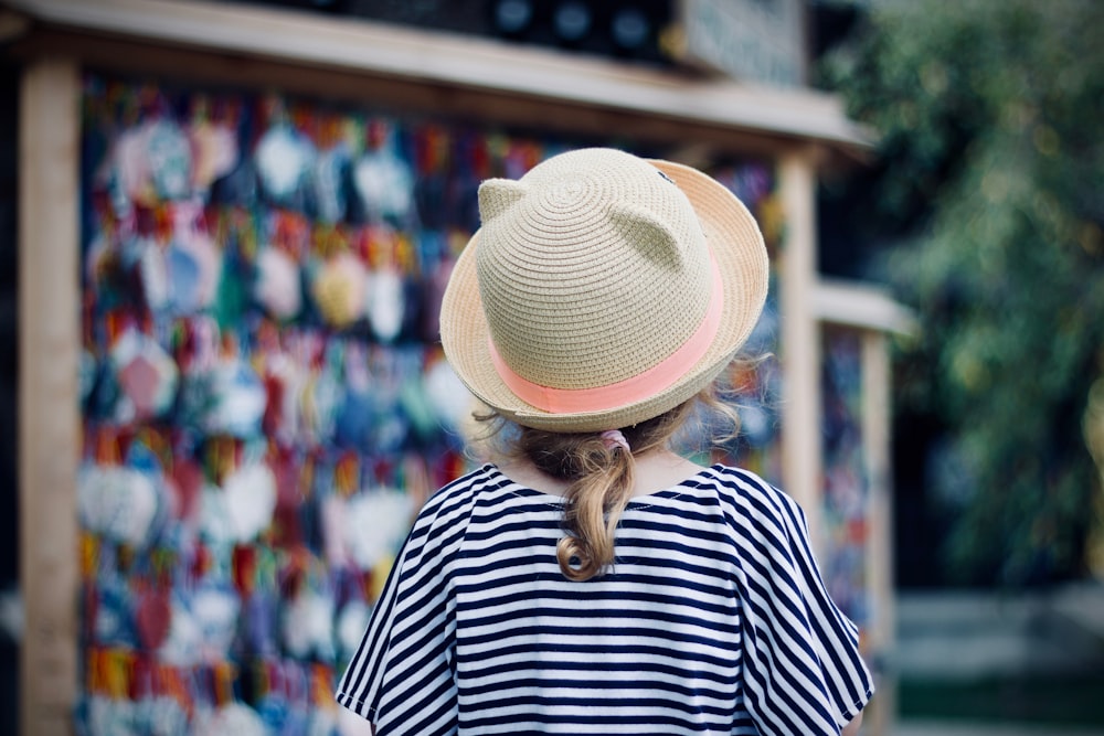 person standing near stall wearing straw hat