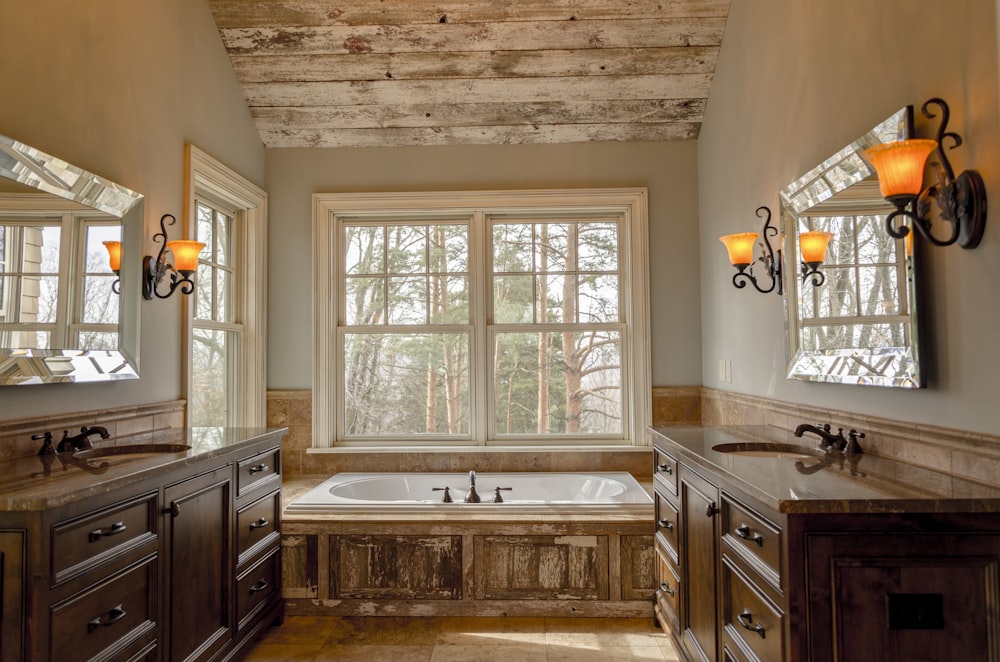 Komfortzimmer mit weißer Badewanne und braunen Holzschränken