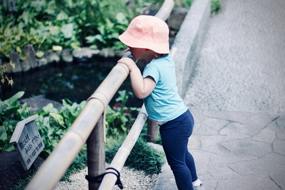 Menina que está na frente da cerca de madeira