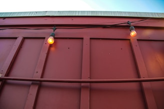 Close-up of an electrician’s hands installing a red lightning bolt outlined panel glowing softly.