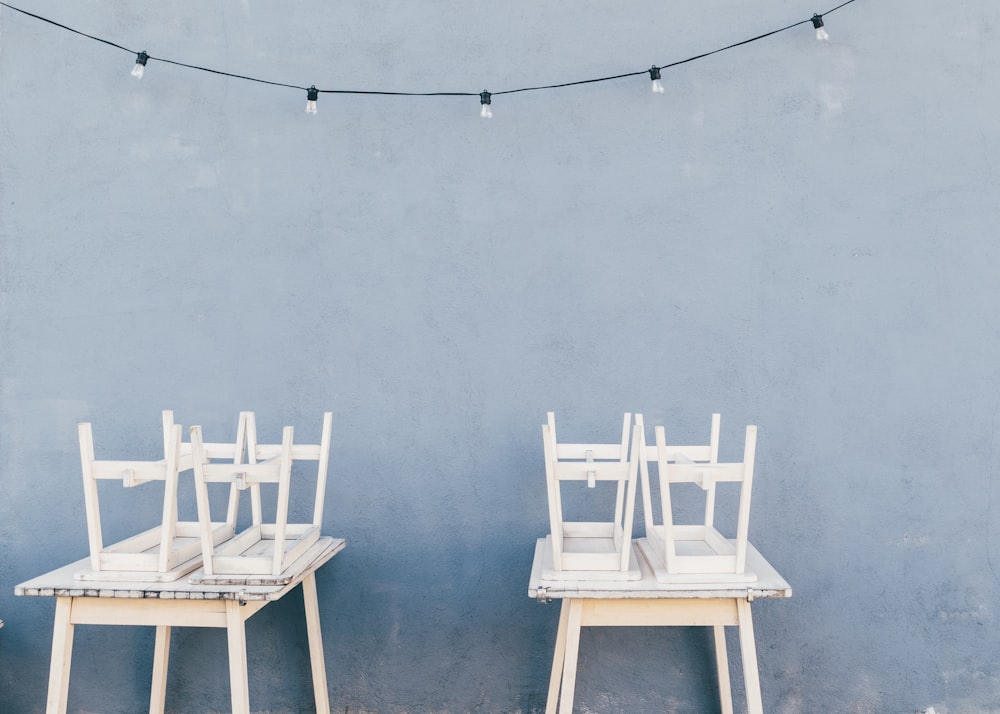 two white wooden 5-piece dining sets