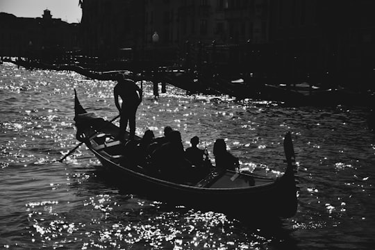 greyscale photography of people riding on boat in Venice Italy
