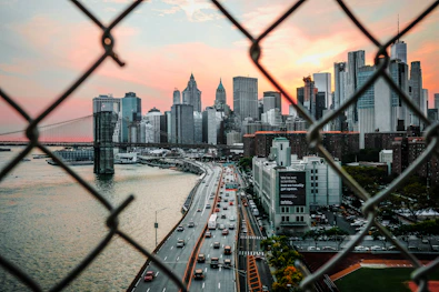 manhattan skyline through chain link fence