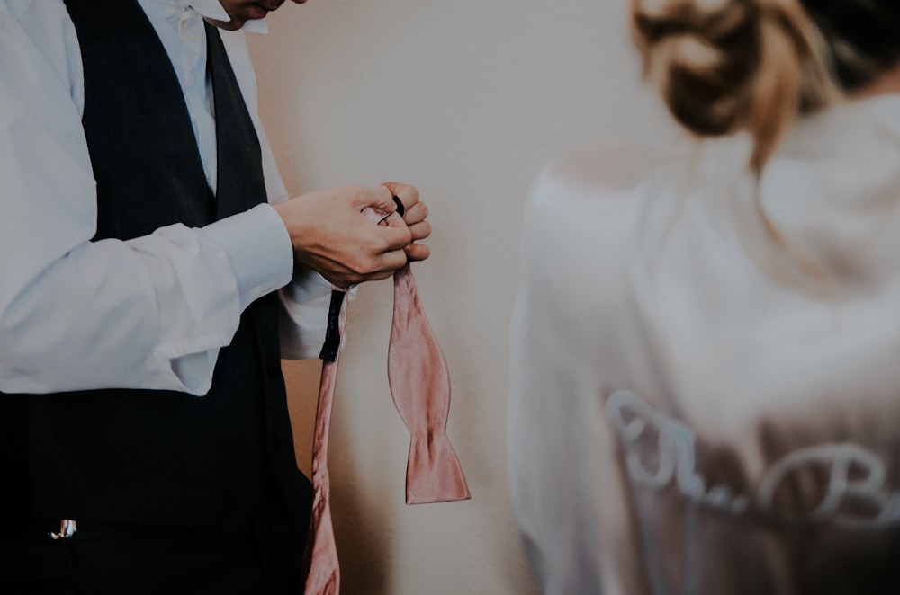 man holding a pink textile inside white room