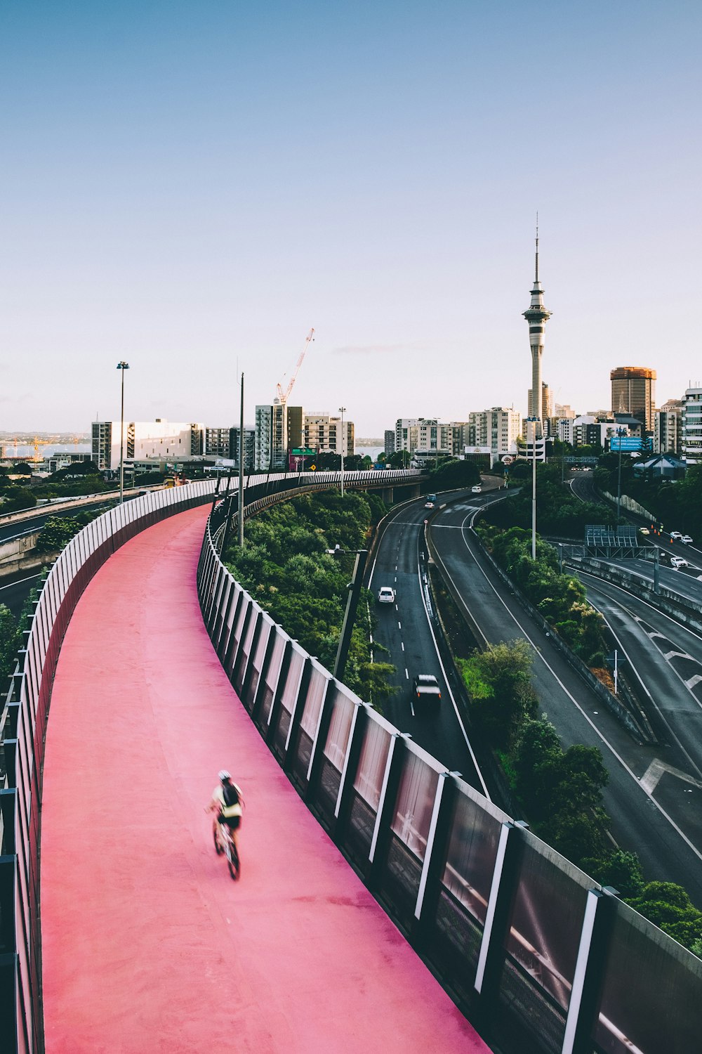 person biking on red concrete road during daytime