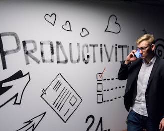 man holding smartphone looking at productivity wall decor