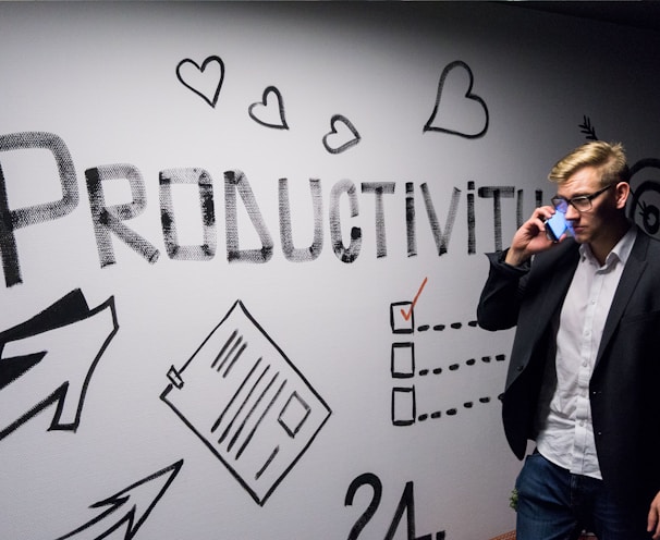 man holding smartphone looking at productivity wall decor