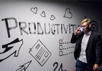 man holding smartphone looking at productivity wall decor