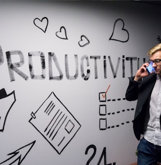 man holding smartphone looking at productivity wall decor