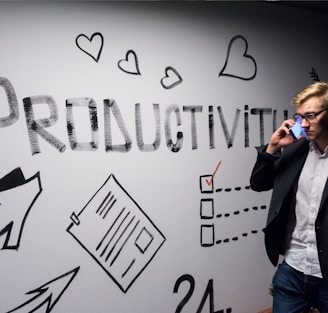 man holding smartphone looking at productivity wall decor