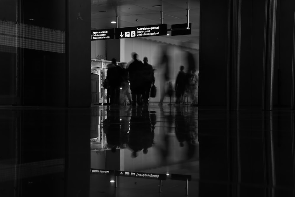 Gruppo di persone in piedi e che camminano nell'area partenze nel terminal