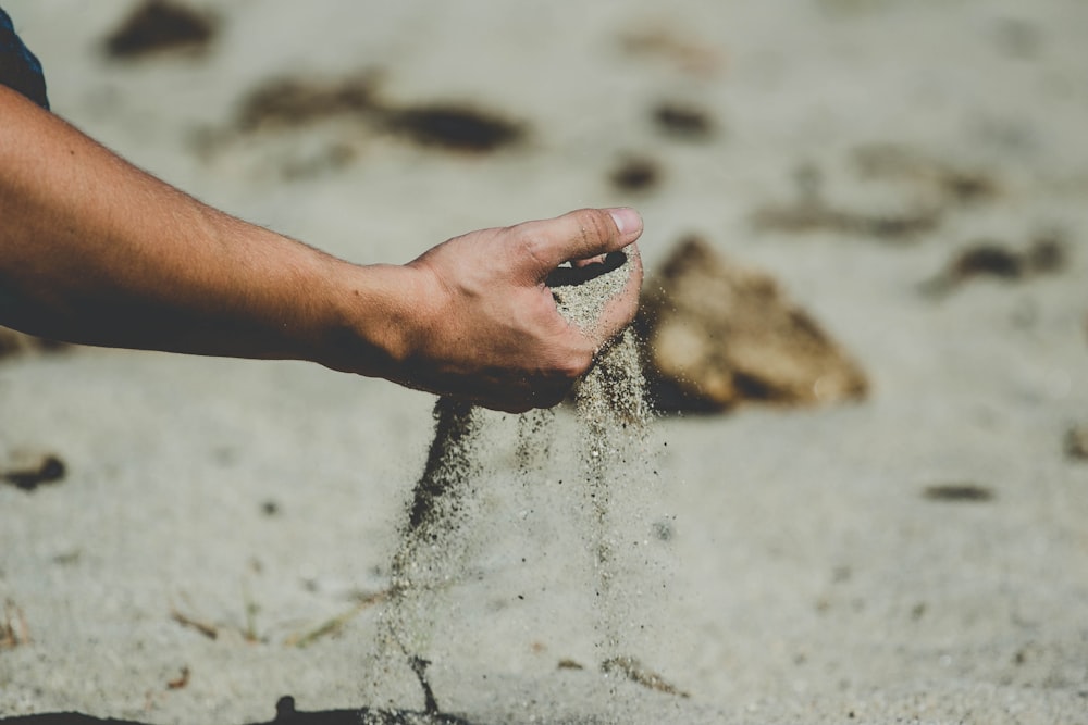 person holding brown sand