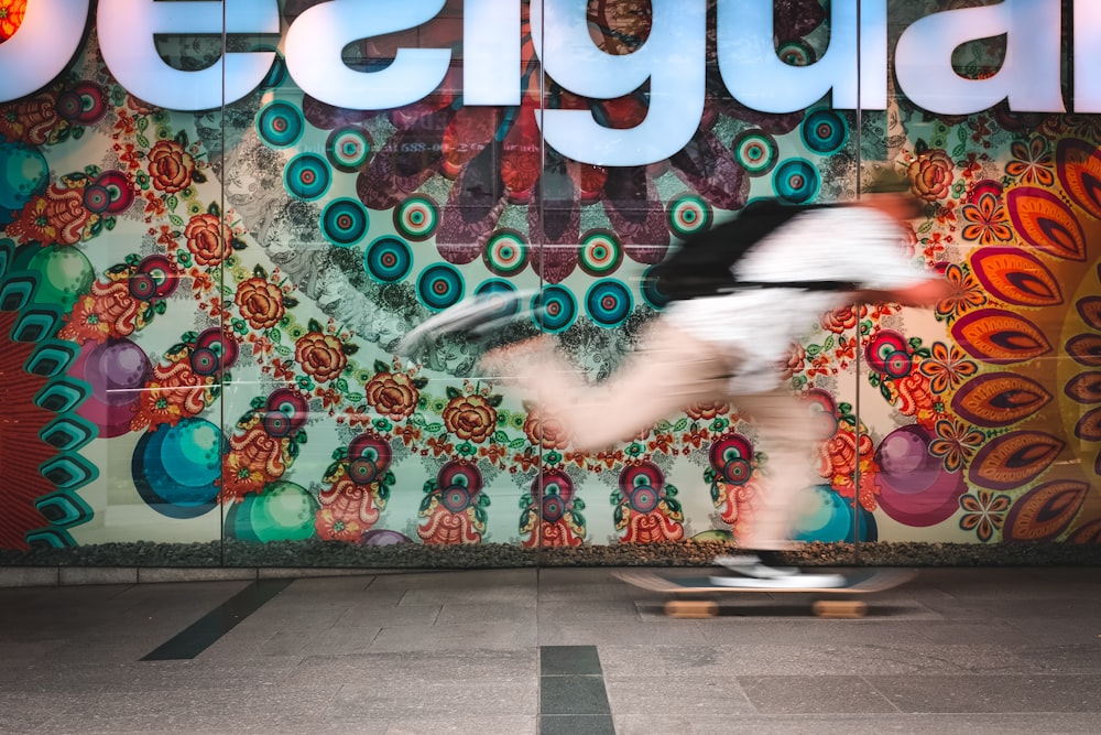 man skating near multicolored concrete wall