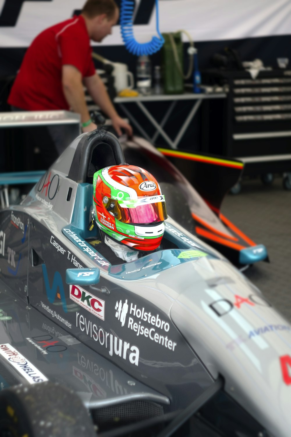 man riding gray and white F1 vehicle inside room