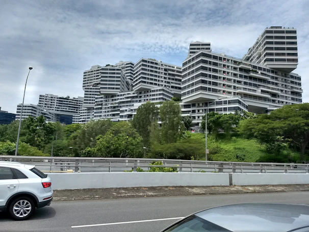 A modern residential and commercial building complex on Sarjapur Road with lush greenery around.