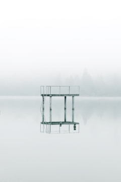 photography gray metal tower near body of water during daytime