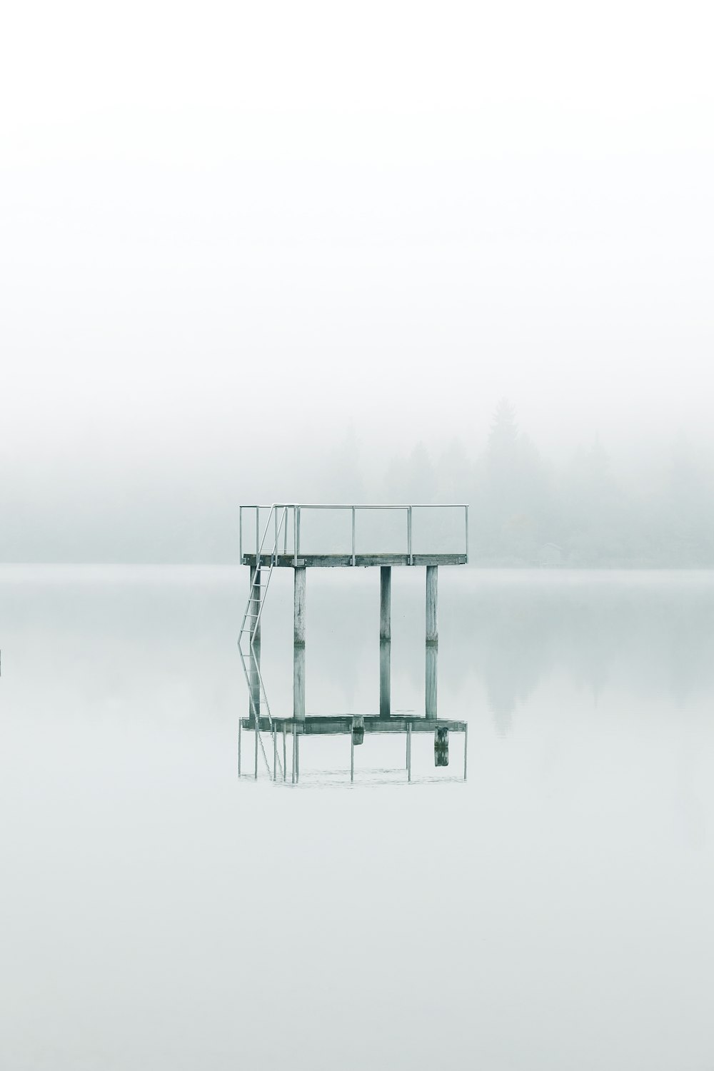 photography gray metal tower near body of water during daytime