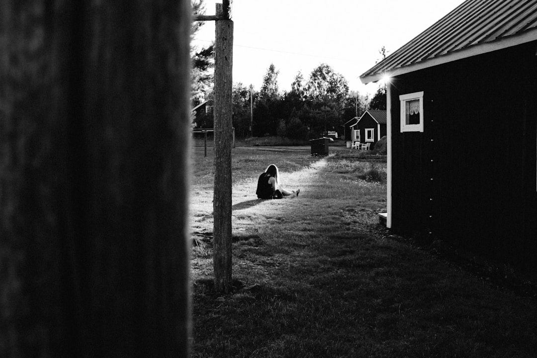 girl sitting on grass near house