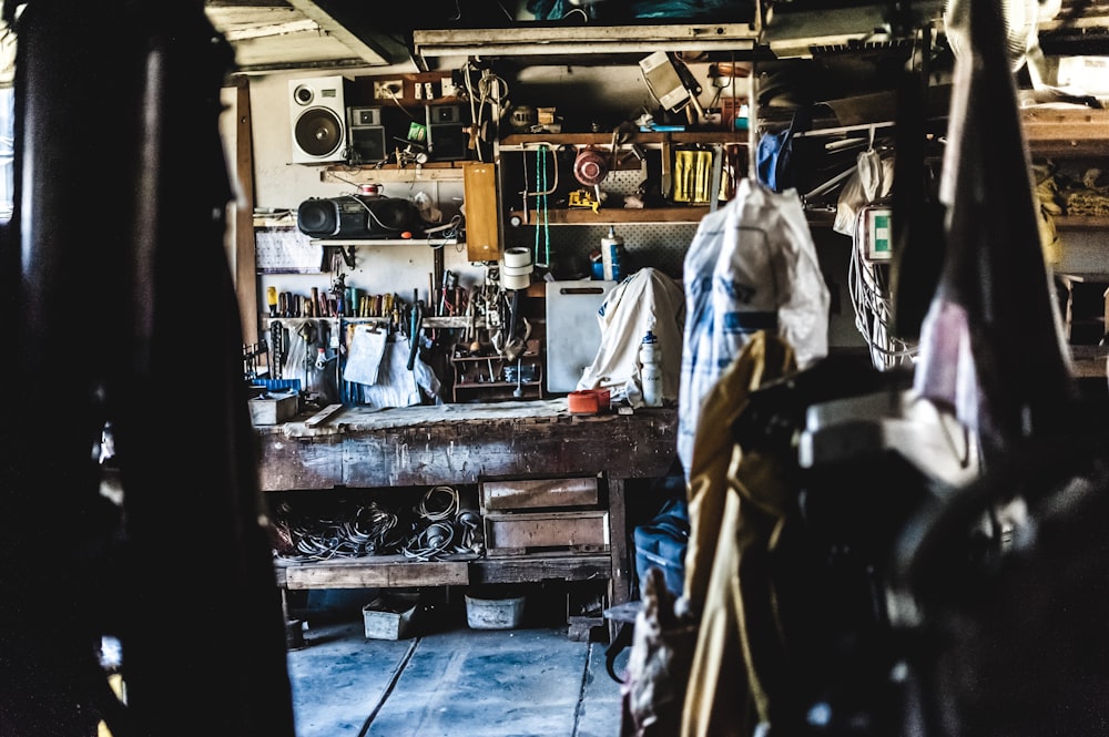 a man standing in a garage next to a workbench