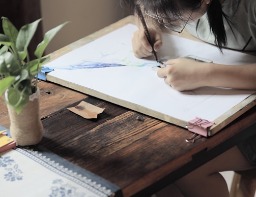 girl doing artwork on board inside well lit room