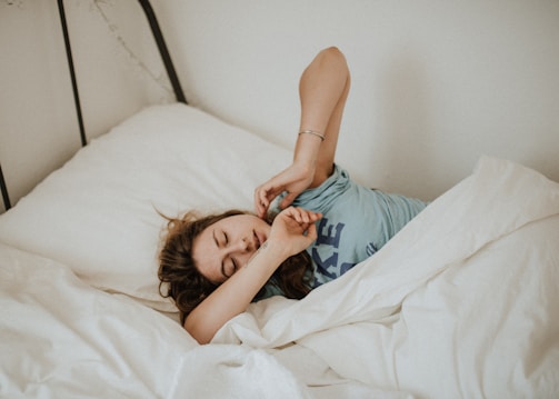 woman covered in white blanket sleeping and being exhausted