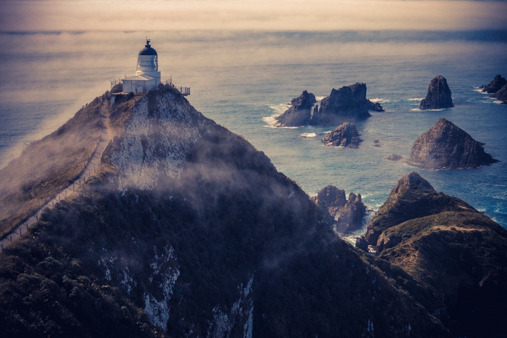 aerial view of a lighthouse atop of mountain