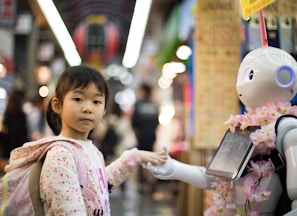 photo of girl laying left hand on white digital robot