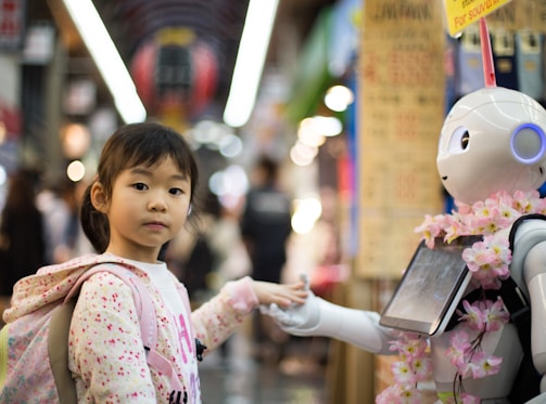 photo of girl laying left hand on white digital robot