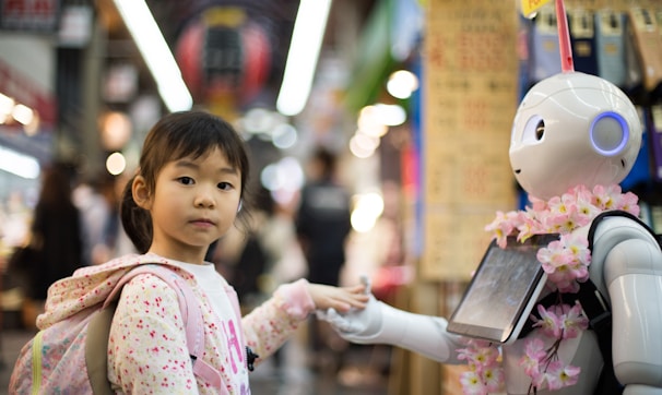 photo of girl laying left hand on white digital robot