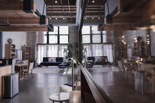 Spacious loft with industrial design and natural light streaming through large windows.