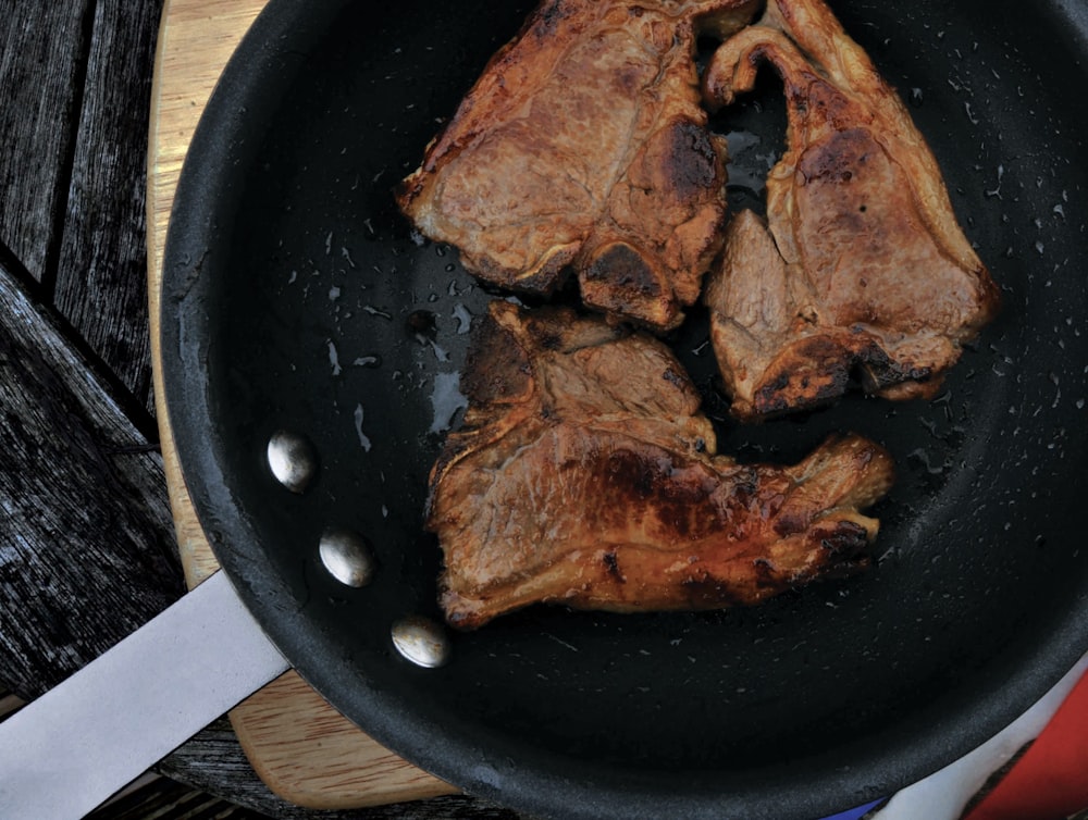 tres carnes fritas en sartén de hierro fundido