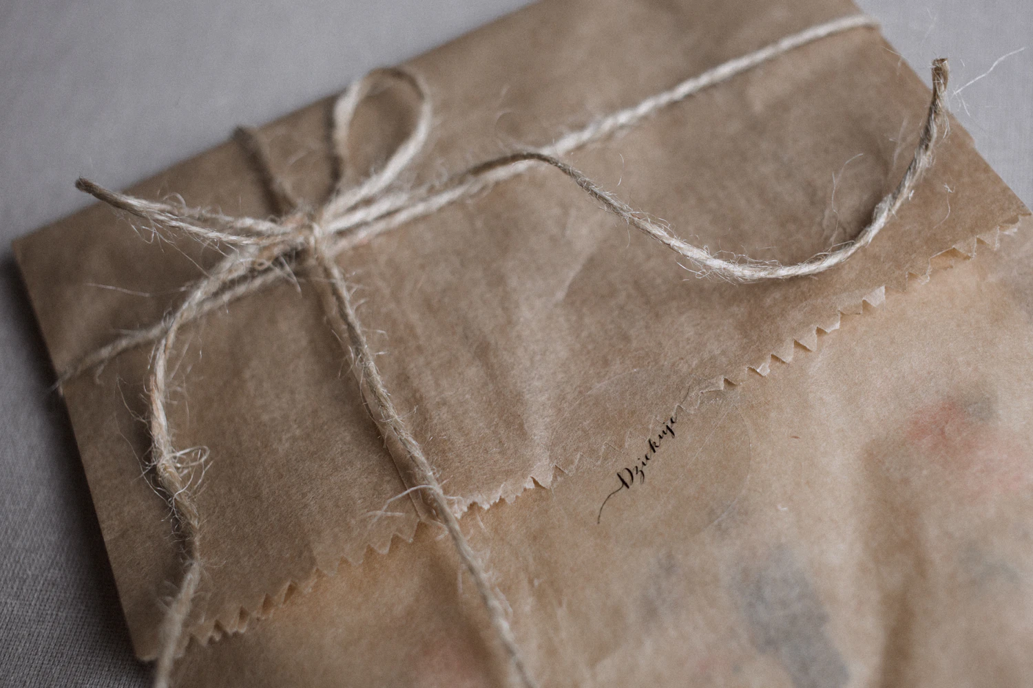 A kraft-paper parcel tied with twine, resting on a grey bench