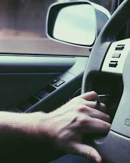 A close-up of a student practicing driving in a car.