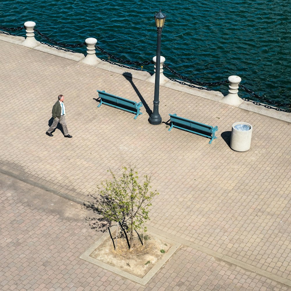 man walking near body of water during day