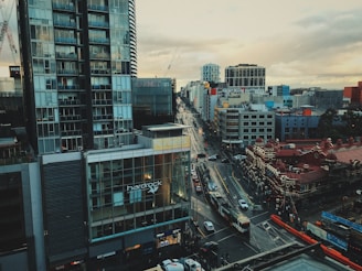 A cityscape featuring modern public transportation vehicles moving along urban streets.