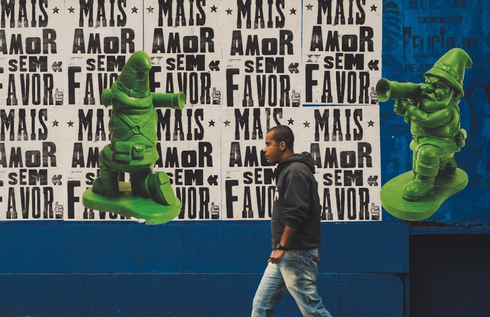 man waling beside a multicolored wall