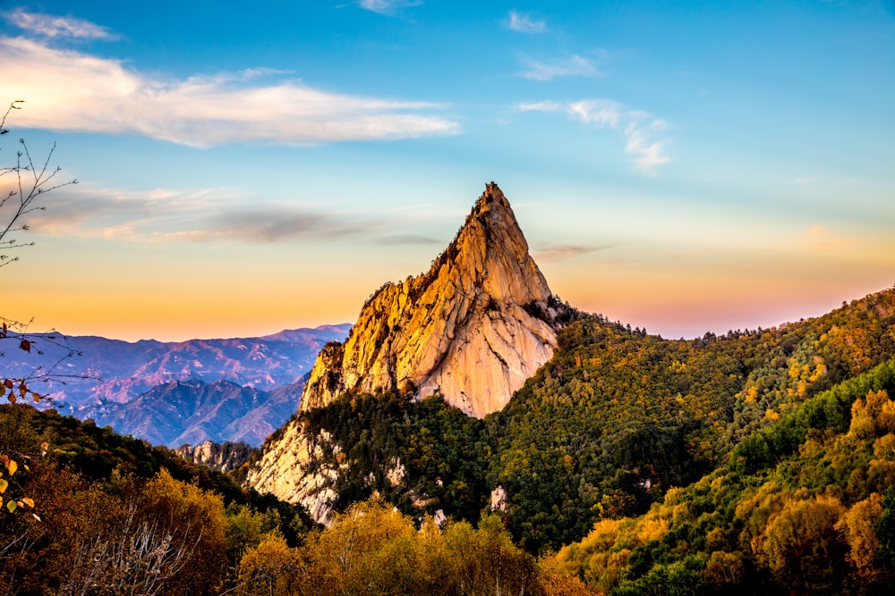 Montaña rocosa marrón bajo cielo nublado azul durante el día